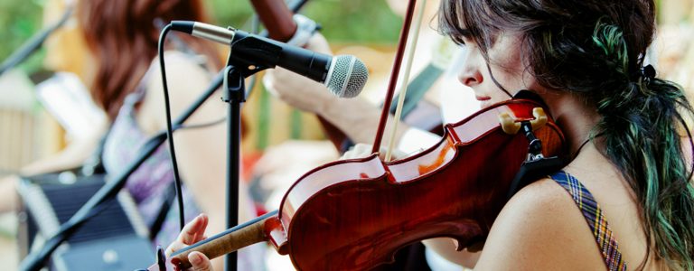 Woman practicing violin on stage